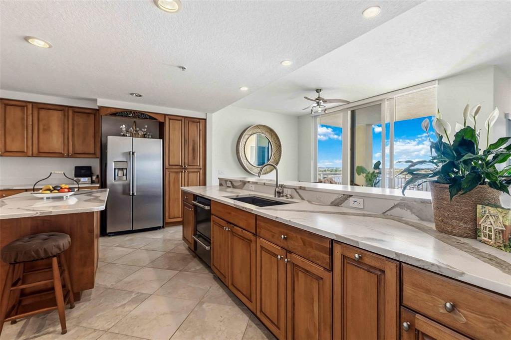 606 Riviera Dunes Way, Unit 601 Palmetto, FL 34221 - Photo 18 of 70 a large kitchen with kitchen island a large counter top space a sink stainless steel appliances and cabinets