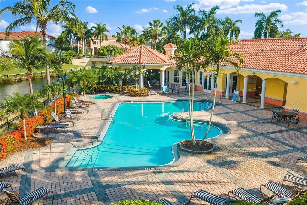 606 Riviera Dunes Way, Unit 601 Palmetto, FL 34221 - Photo 63 of 70 a view of a swimming pool with lounge chairs