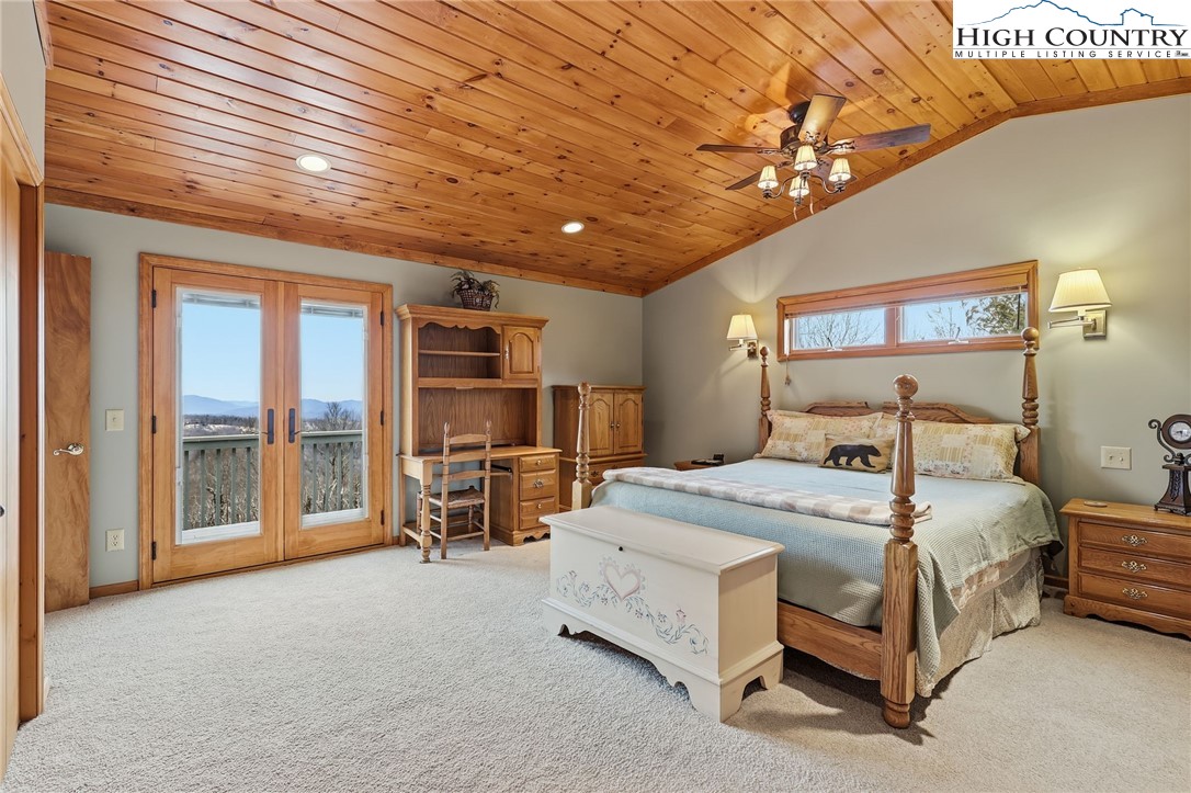 112 North Pinnacle Ridge Road Beech Mountain, NC 28604 - Photo 14 of 40 a spacious bedroom with a bed a table and large windows