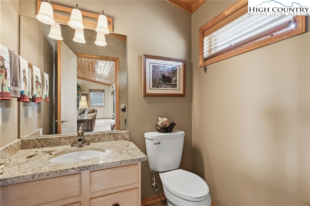 112 North Pinnacle Ridge Road Beech Mountain, NC 28604 - Photo 17 of 40 a bathroom with a granite countertop sink mirror vanity and toilet