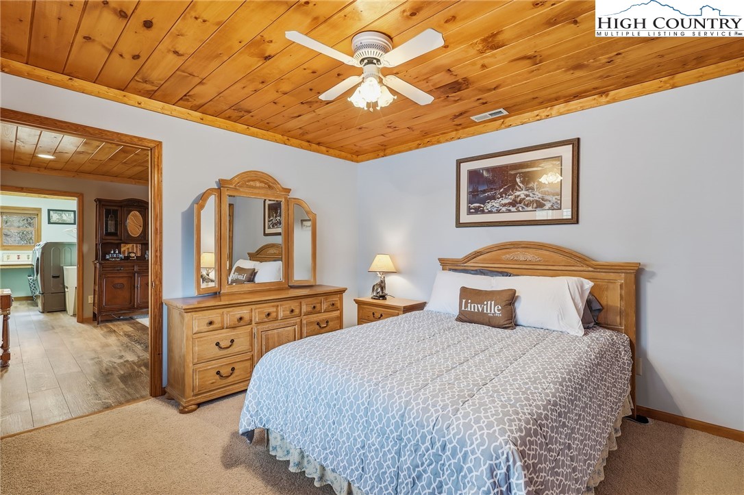 112 North Pinnacle Ridge Road Beech Mountain, NC 28604 - Photo 27 of 40 a bedroom with a bed and a chandelier