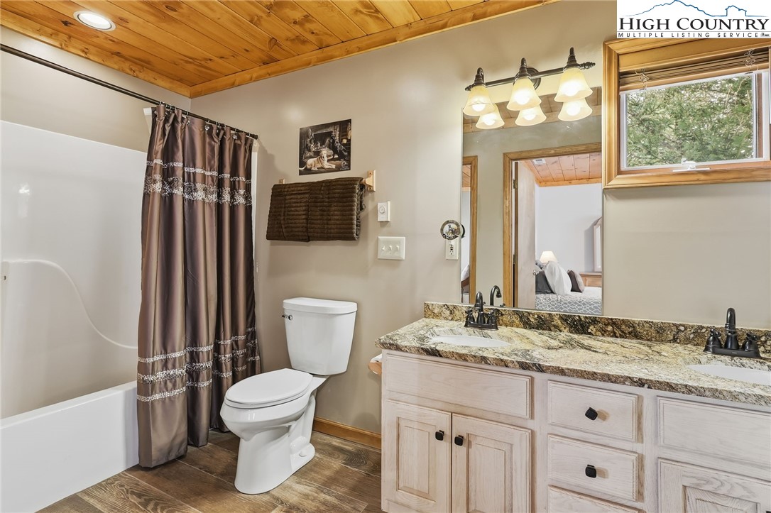 112 North Pinnacle Ridge Road Beech Mountain, NC 28604 - Photo 28 of 40 a bathroom with a granite countertop sink toilet a mirror and bathtub