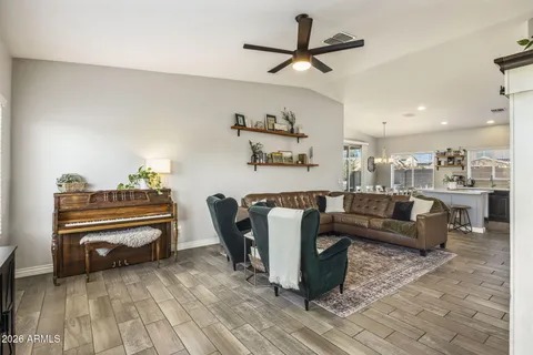 a living room with furniture a clock and a ceiling fan