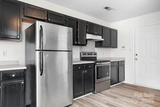 a kitchen with stainless steel appliances a refrigerator stove and sink