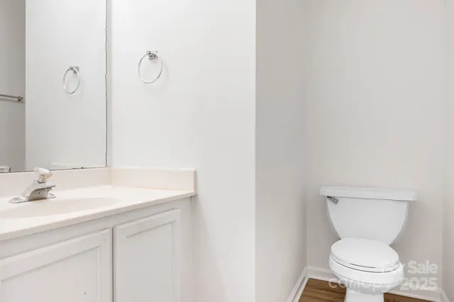 a bathroom with a toilet sink vanity and mirror