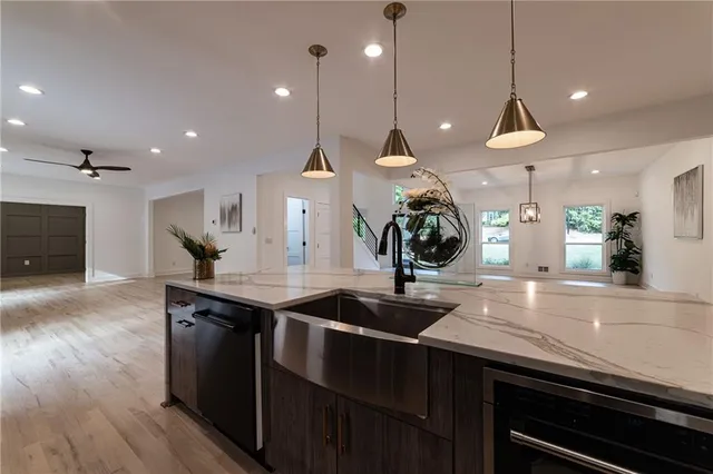 a large kitchen with kitchen island a sink stainless steel appliances and a fireplace