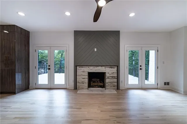 a view of a livingroom with a large window and wooden floor