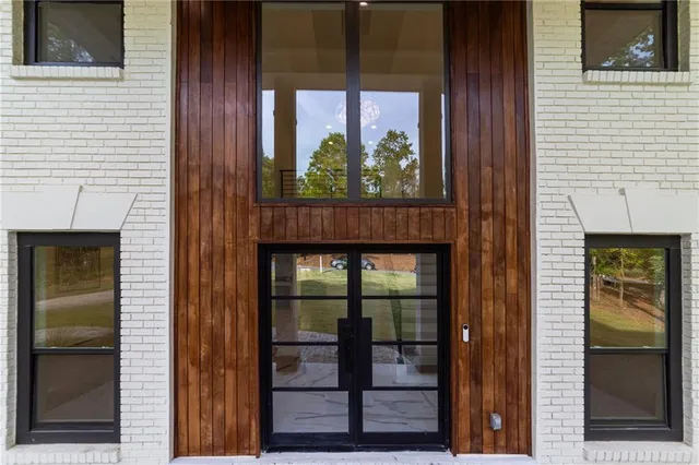 a view of an empty room with kitchen and window