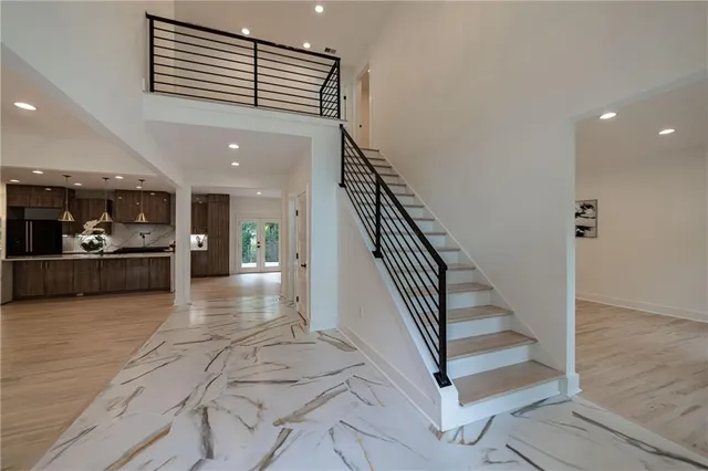 a large kitchen with stainless steel appliances kitchen island granite countertop a large counter top a stove and a refrigerator