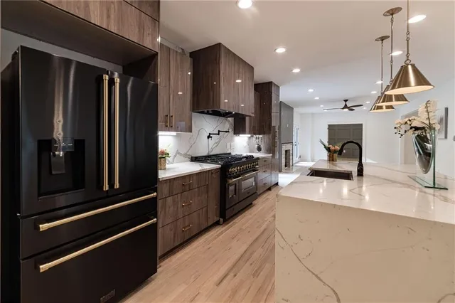 a kitchen with stainless steel appliances kitchen island wooden floors stove and white cabinets