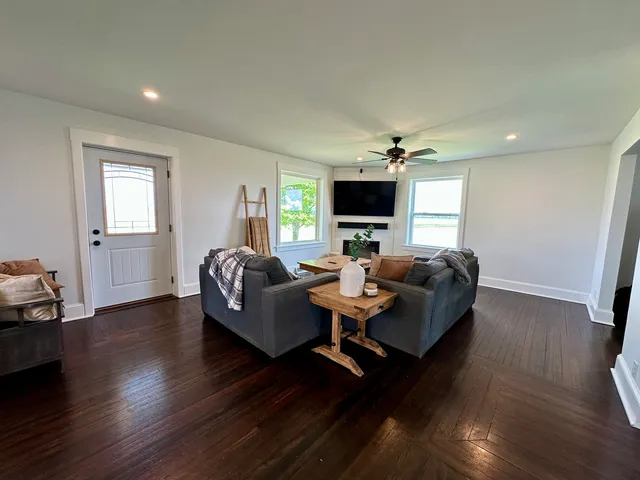 a living room with furniture flat screen tv and wooden floor
