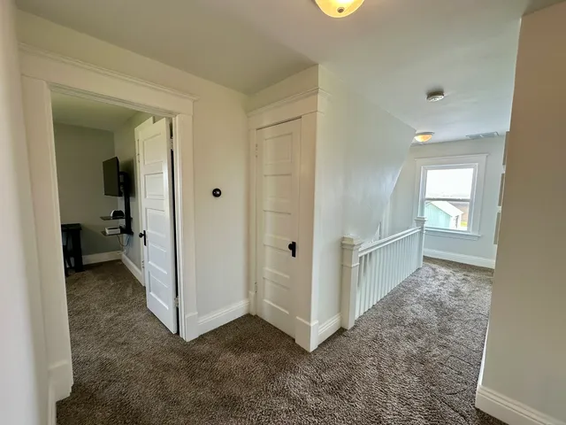 a view of a hallway with closet and wooden floor