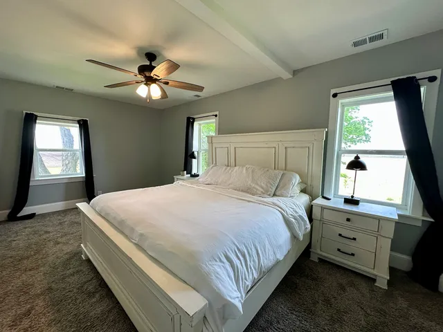 a bedroom with a bed dresser and a window