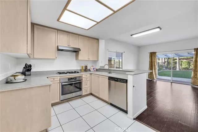 a kitchen with stainless steel appliances granite countertop a stove a sink dishwasher and a refrigerator