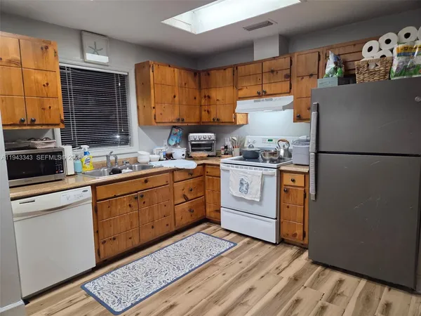 a kitchen with a sink cabinets stainless steel appliances and a window