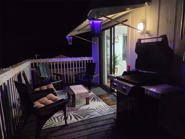 a balcony with wooden floor table and chairs