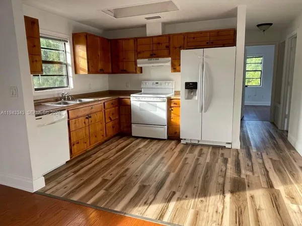 a kitchen with granite countertop white cabinets and white appliances