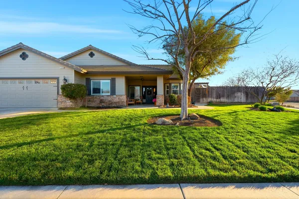 a front view of a house with yard and green space