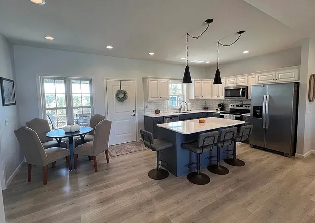 a kitchen with a table chairs refrigerator and microwave