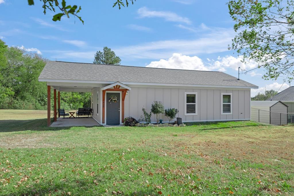 a view of a house with a yard and a porch