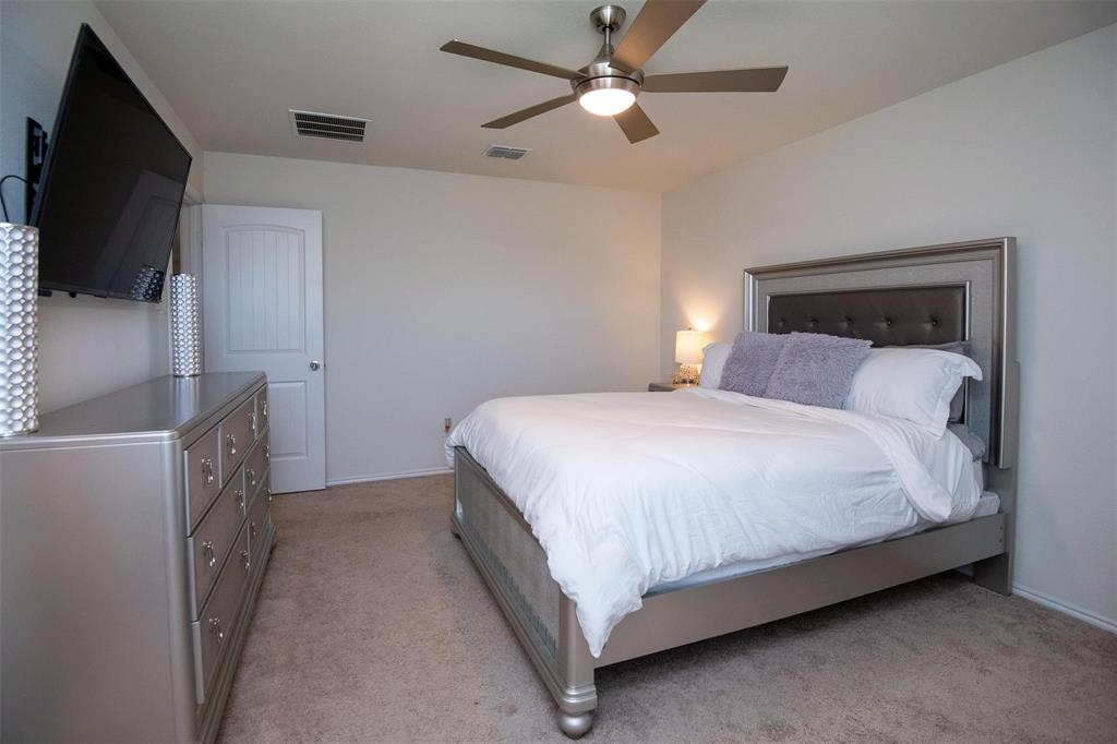 1215 Fairford Road Crandall, TX 75114 - Photo 8 of 20 a bedroom with a bed and a flat tv screen on the dresser