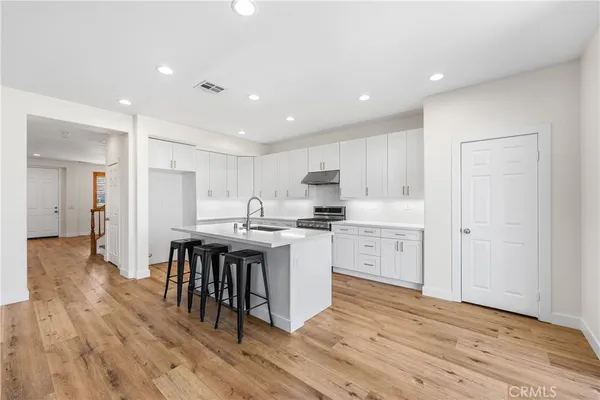 a kitchen with white cabinets sink and stainless steel appliances
