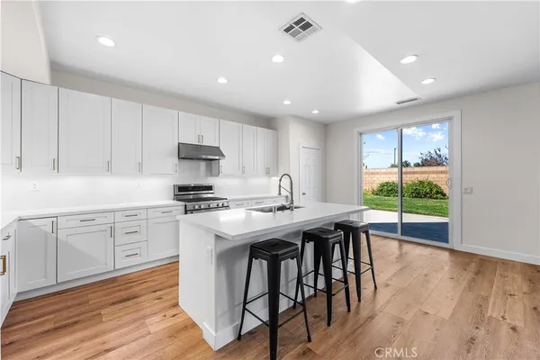 a kitchen with granite countertop a stove sink and cabinets