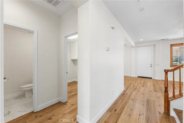 a view of a room with wooden floor and a ceiling fan