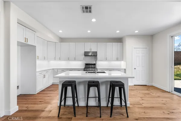 a kitchen with granite countertop a sink a counter top space stainless steel appliances and cabinets