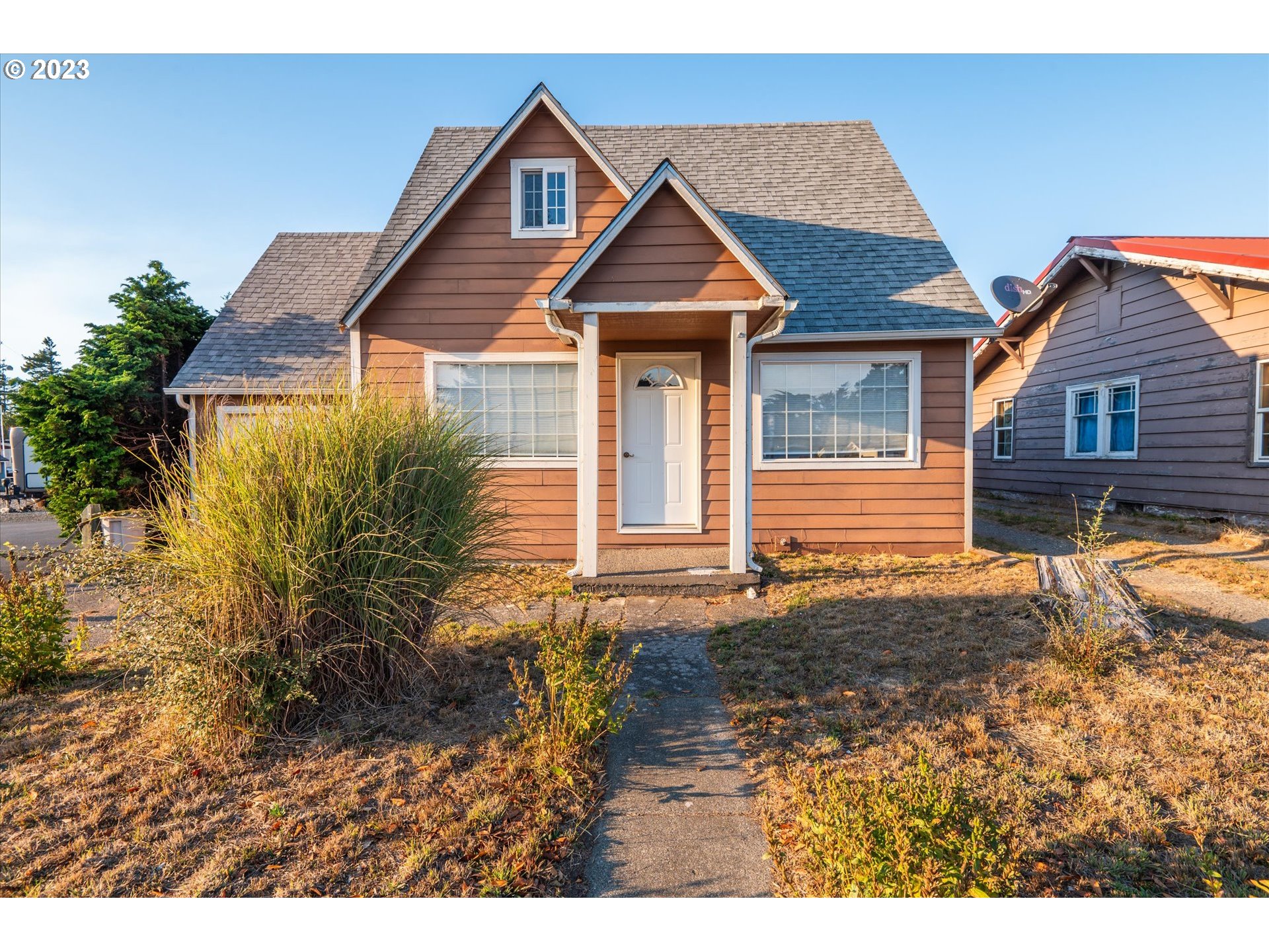 945 2nd Street Southeast Bandon, OR 97411 - Photo 1 of 29 a front view of a house with a yard and garage