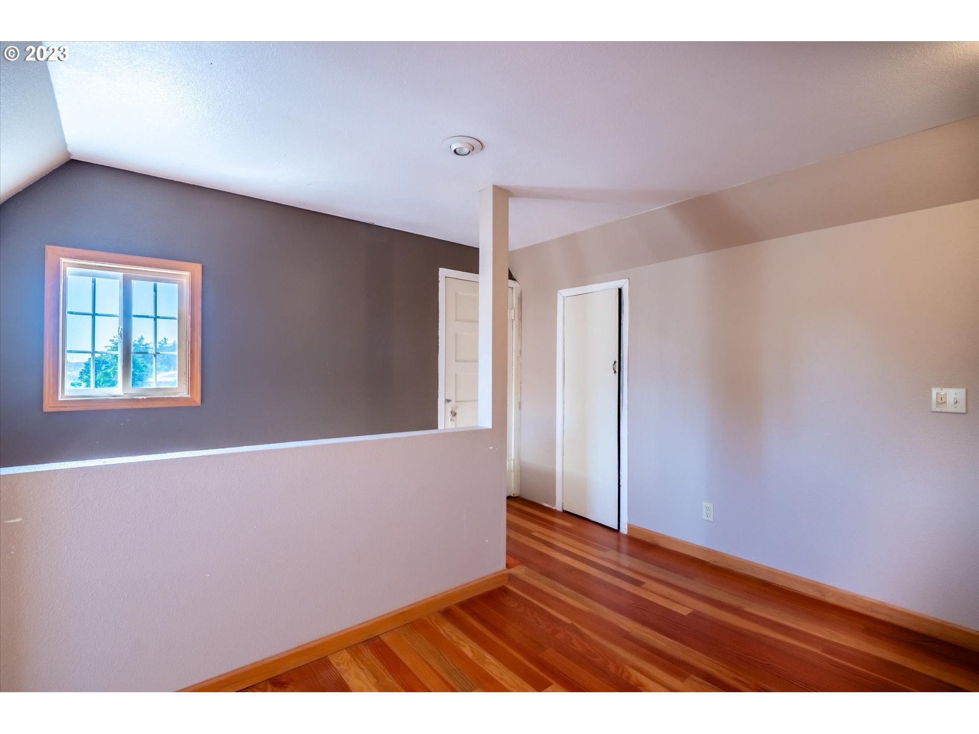945 2nd Street Southeast Bandon, OR 97411 - Photo 16 of 29 a view of an empty room with wooden floor and a window