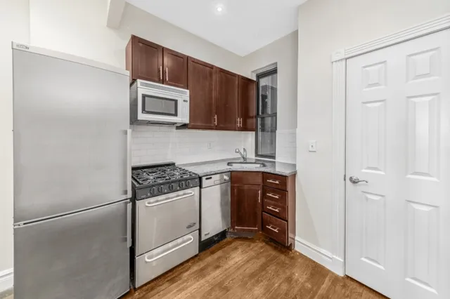 a kitchen with stainless steel appliances granite countertop a stove a microwave and a refrigerator