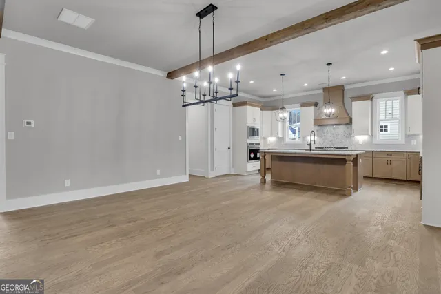 a kitchen with kitchen island granite countertop a sink cabinets and stainless steel appliances