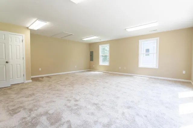 an empty room with windows and closet