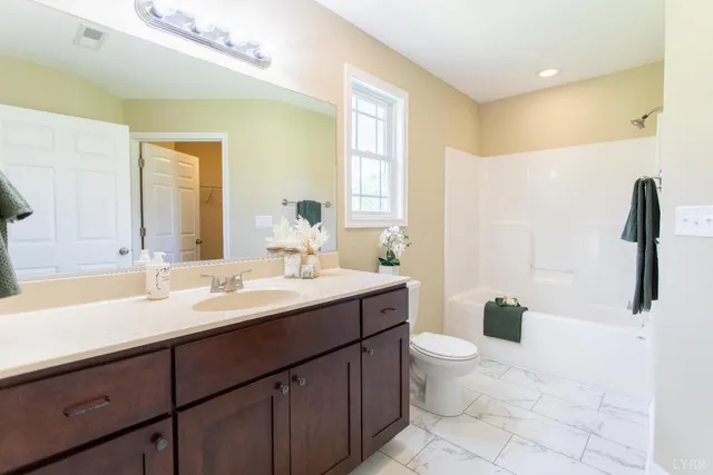 a bathroom with a double vanity sink toilet and a mirror