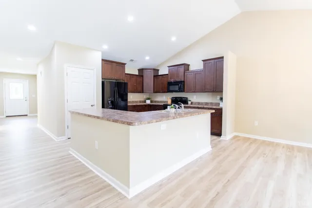 a large kitchen with stainless steel appliances granite countertop a stove a sink and a refrigerator