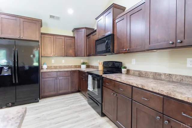 a kitchen with stainless steel appliances granite countertop a sink stove and cabinets