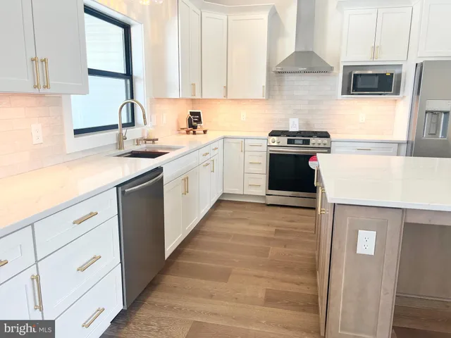 a kitchen with a sink dishwasher a stove and a microwave oven with cabinets