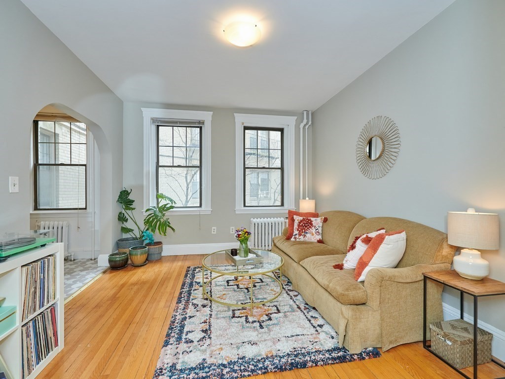 a living room with a couch and dresser with wooden floor