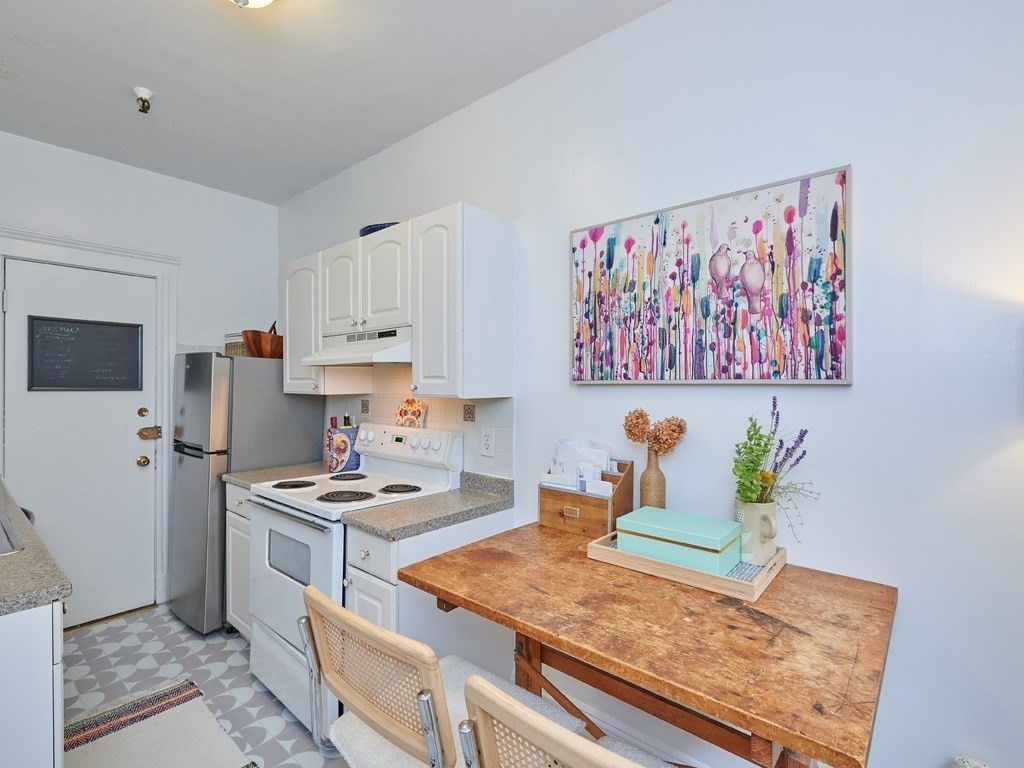 2 Sutherland Road, Unit 2 Boston, MA 02135 - Photo 4 of 11 a kitchen with stainless steel appliances granite countertop a sink stove and refrigerator