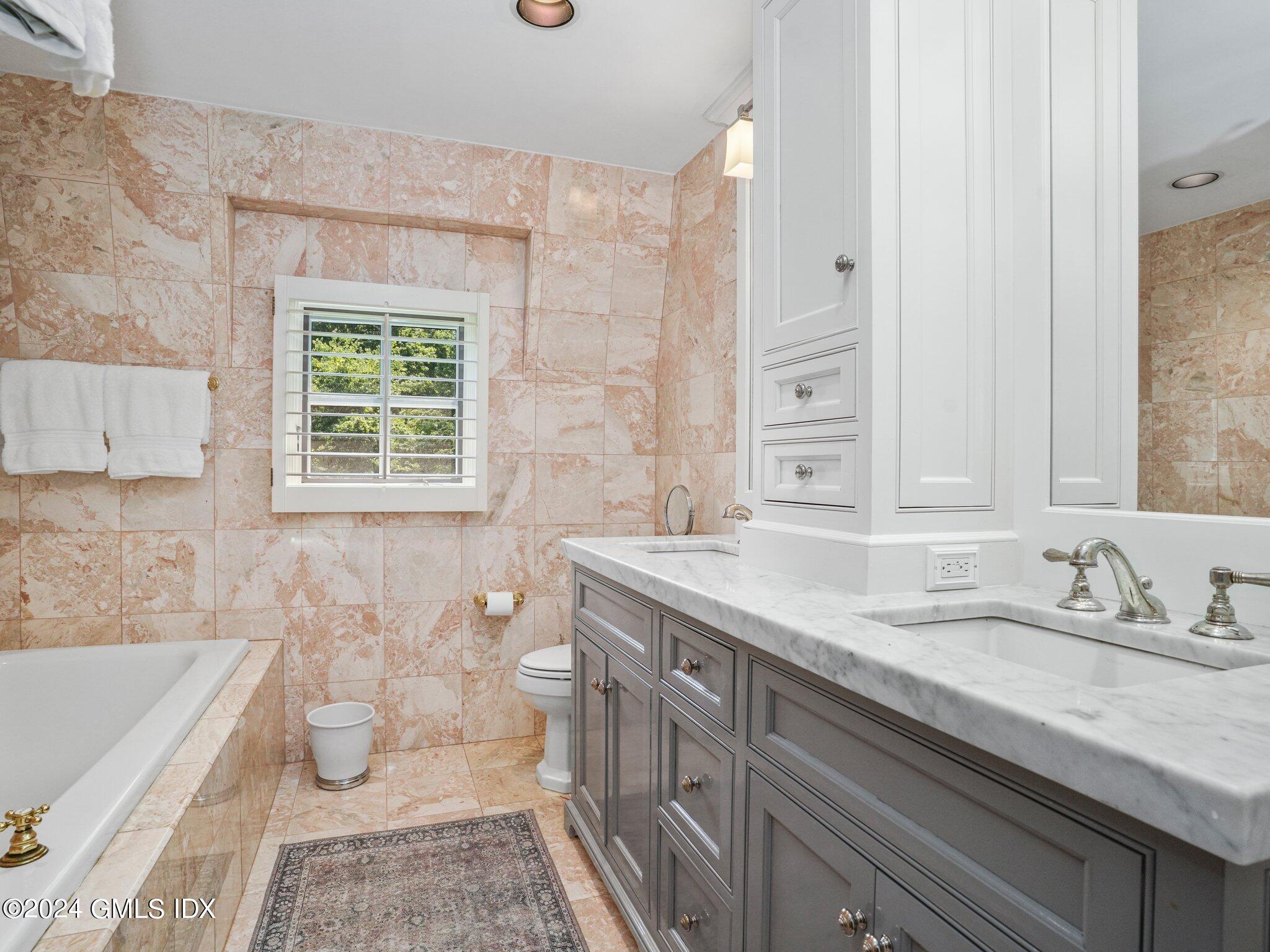 80 Porchuck Road Greenwich, CT 06831 - Photo 18 of 29 a bathroom with a granite countertop double vanity sink a mirror and a bathtub