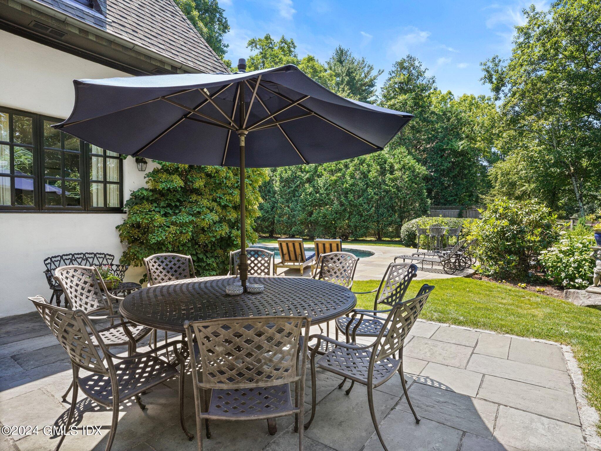 80 Porchuck Road Greenwich, CT 06831 - Photo 25 of 29 a table and chairs under an umbrella