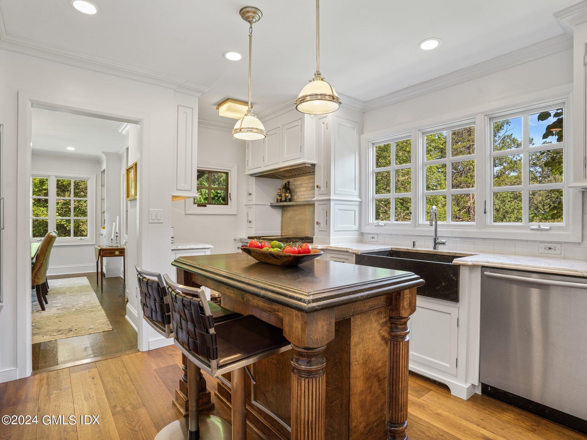 80 Porchuck Road Greenwich, CT 06831 - Photo 9 of 29 a kitchen with a stove a sink a chandelier and wooden floor