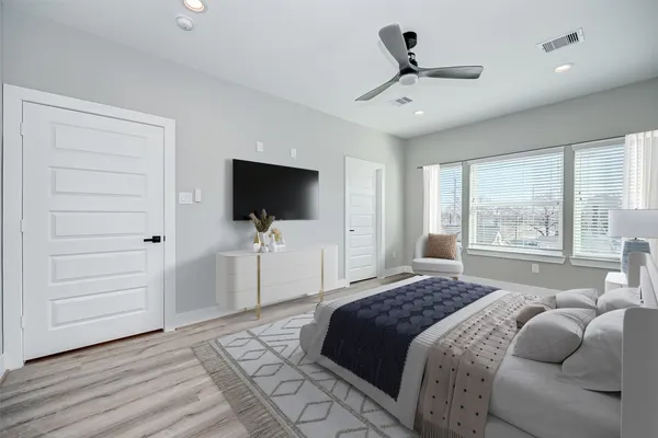 a bedroom with a bed tv and a window