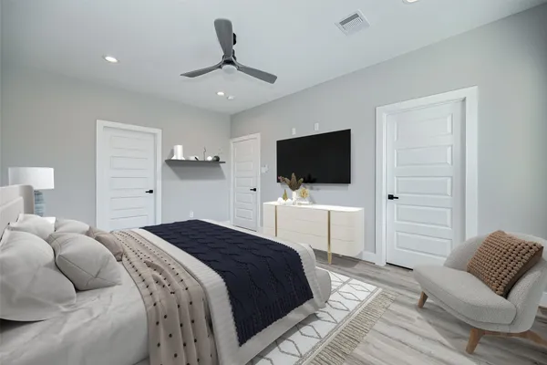 a bedroom with a bed tv and chair