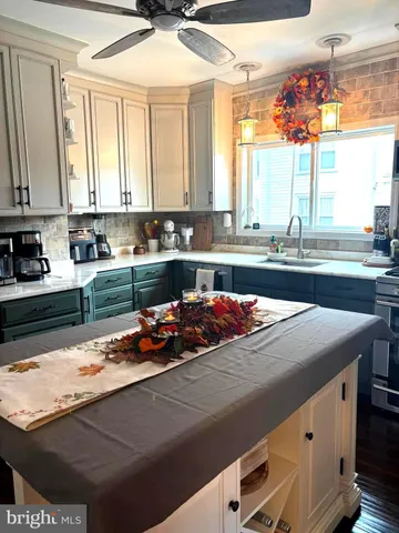 a kitchen with kitchen island granite countertop a sink and a stove