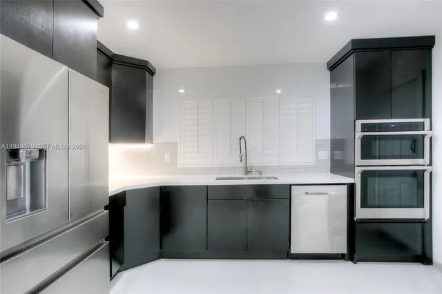 a kitchen with stainless steel appliances a sink and cabinets