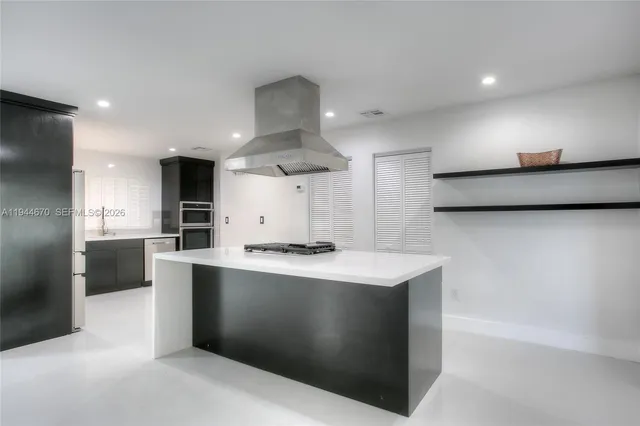 a kitchen with stainless steel appliances a sink a stove a refrigerator and a oven