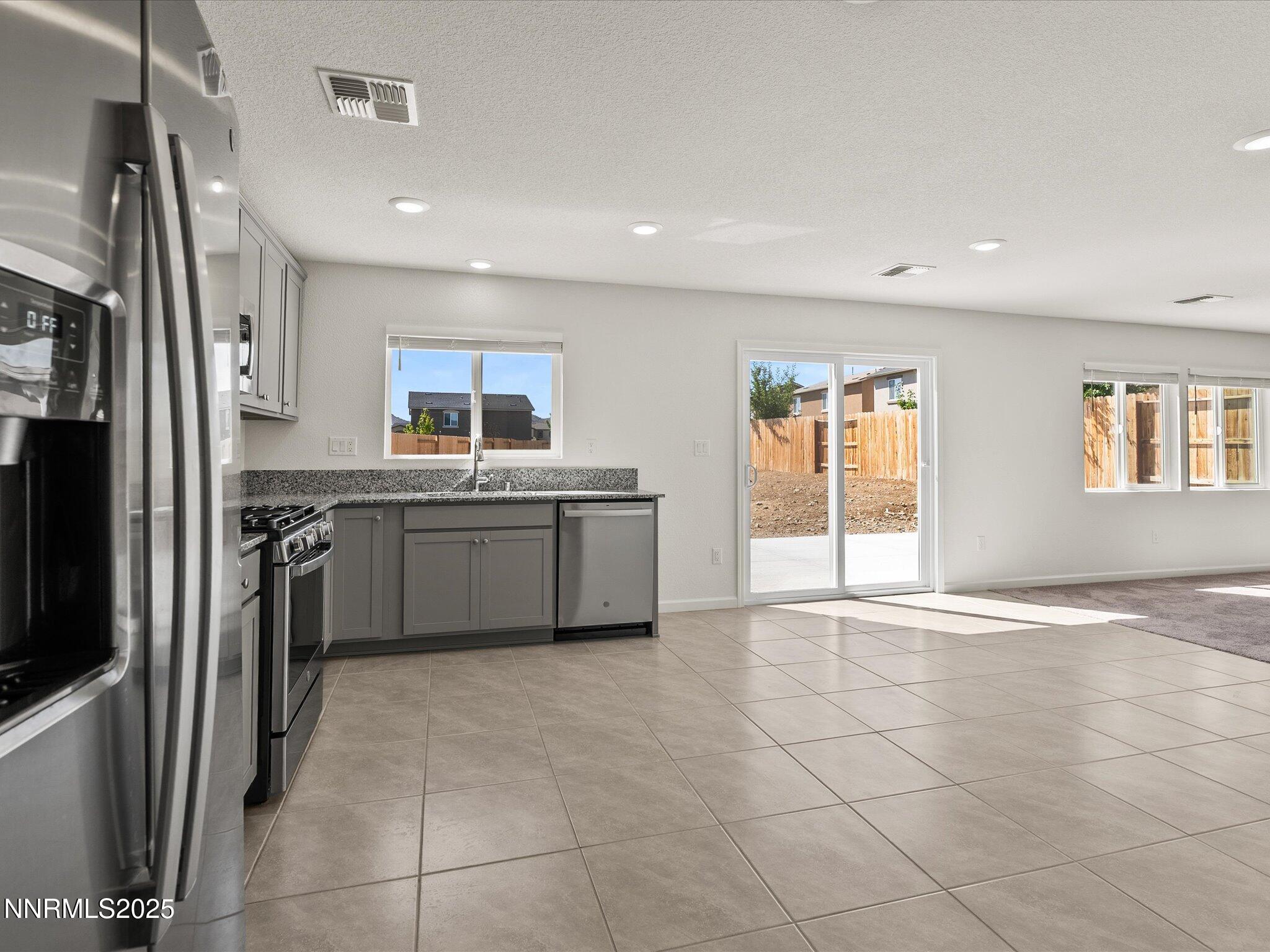 8838 Finnsech Drive Reno, NV 89506 - Photo 16 of 44 a kitchen with stainless steel appliances granite countertop a sink stove and refrigerator