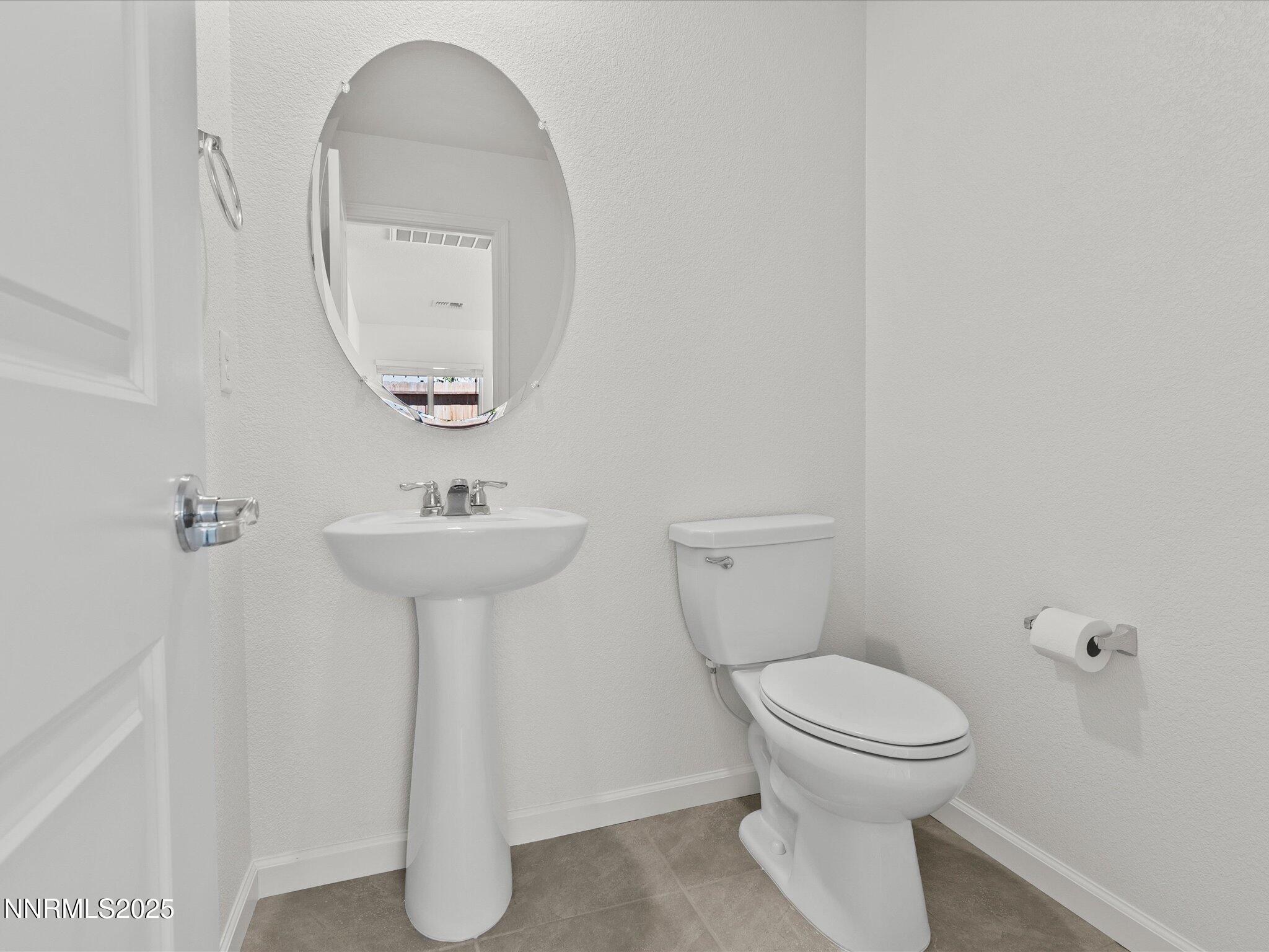 8838 Finnsech Drive Reno, NV 89506 - Photo 18 of 44 a bathroom with a toilet sink and mirror